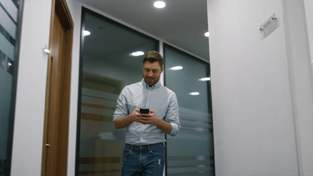 istock Smiling manager walking office alone calling mobile phone in business centre. 1466839696