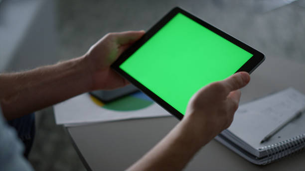 istock Man hands using tablet device green screen research business finance in office. 1466841905