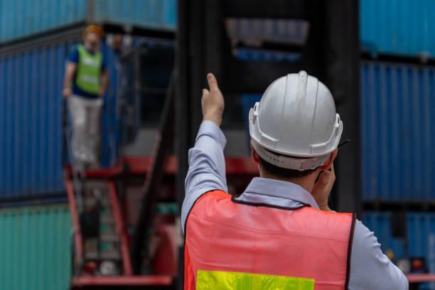 istock Industrial worker works with co-worker at overseas shipping container yard . Logistics supply chain management and international goods export concept . 1466846703