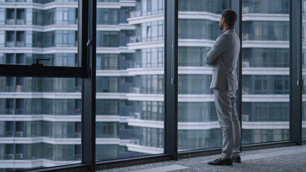 istock Successful man crossing hands looking window in business office building centre. 1466849934
