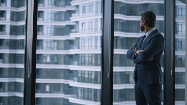 istock Successful businessman crossing hands looking window wall in corporate building. 1466850853