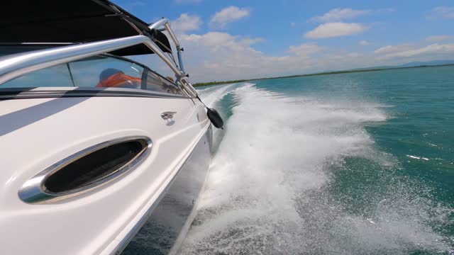 High speed motorboat moving fast on the surface of the sea. Splash from dissected waves. Side view of the vessel