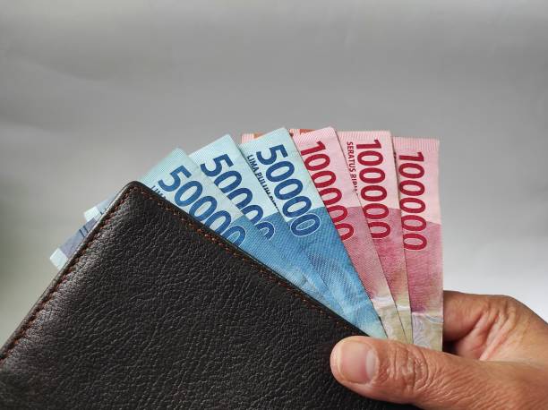 istock Human hands holding 50000 and 100000 rupiah banknotes 1466858557