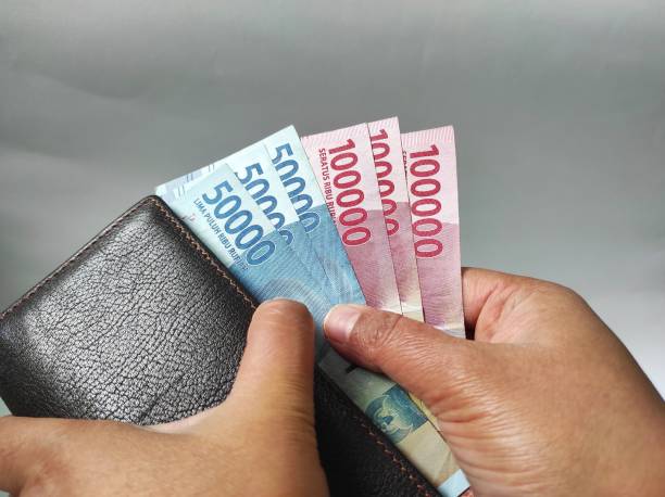 istock Human hands holding 50000 and 100000 rupiah banknotes 1466858561