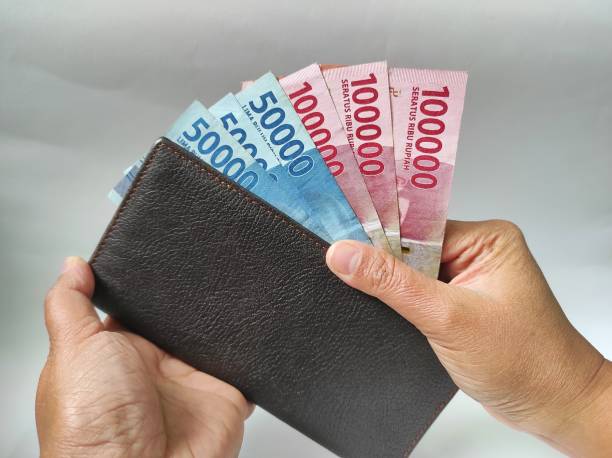 istock Human hands holding 50000 and 100000 rupiah banknotes 1466858566