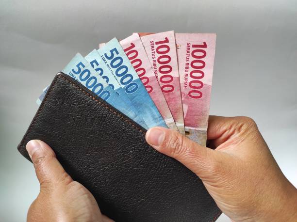 istock Human hands holding 50000 and 100000 rupiah banknotes 1466858570