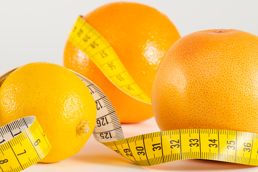 Orange Grapefruit and lemon with measure tape pointing health lifestyle.