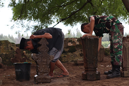 Indonesian Army troops carry out mutual cooperation cleaning and arrangement of the ancient 18th century Aceh royal tombs in Alue Deah Tunong Village, Meuraxa District, Banda Aceh City