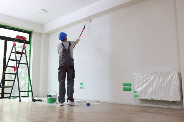 professional painter paints office wall with roller brush. - schilder stockfoto's en -beelden