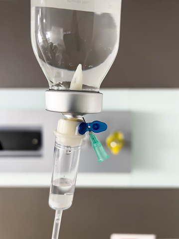 Saline iv drip fluid intravenous drop hanging in hospital room with copy space. medical treatment emergency concept
