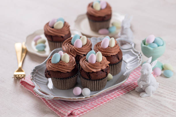 istock Homemade Easter vanilla cupcakes bird's nest with butter cream, chocolate and candy eggs on a dish. 1466890776