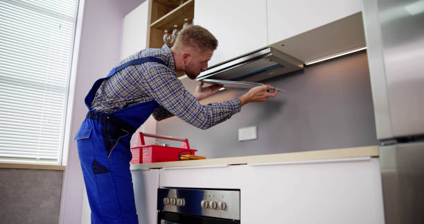 istock Young Handyman In Overall Fixing Kitchen Extractor Fan 1466896257