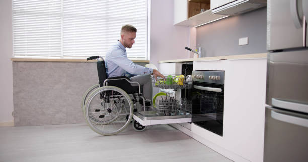istock Person With Disability In Wheelchair Using Dishwasher 1466897194