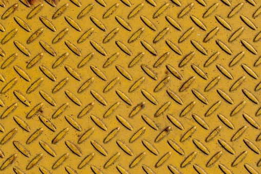 Yellow steel plate for a background design element with copy space as a symbol of masculinity and industry.