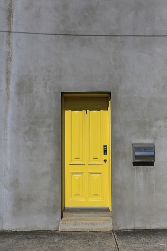 Yellow door in a plain concrete facade