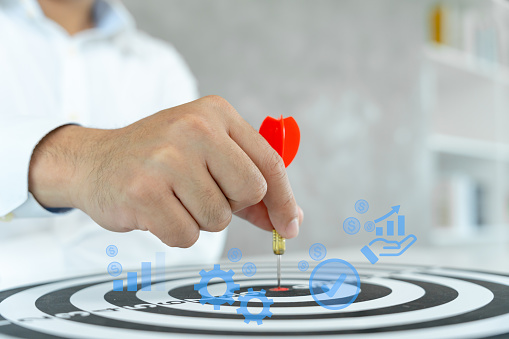 Businessman set goals for work. Hand holding a dart aiming at the target center business. goal, aiming marketing target metaphor, Succeed dart board, defines objectives, success investment ideas.