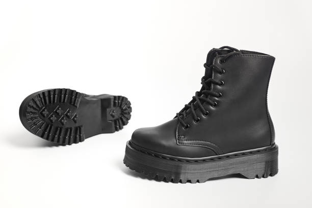 istock Black women combat boots on high heel platform with lug soles lying on isolated white background 1466914748