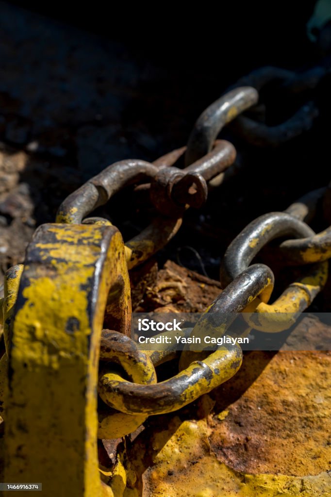 bollard and chain yellow paint partially peeled off, pier bollard and chain. Selective Focus Chain. Anchor - Vessel Part Stock Photo