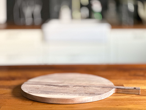 Empty pizza cutting board on kitchen counter