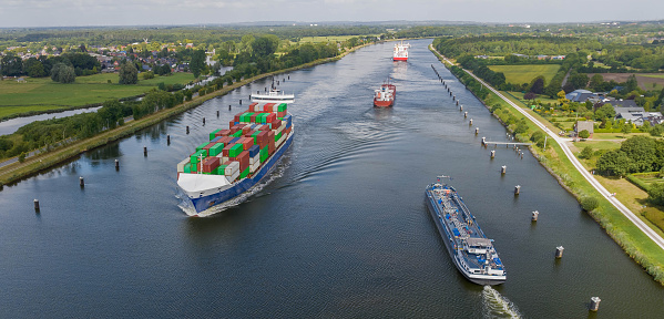 Ship traffic on the Kiel Canal or Nord-Ostsee-Kanal near Rendsburg, Schleswig-Holstein, Germany. Kiel canal runs along the Eider river, where both bodies of water are partly separated by a road.