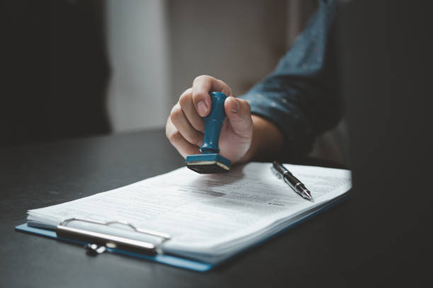 istock Signing approval record documents stamp confirmation occupation signature. businessman hand stamping finance paper work concept. 1466924656
