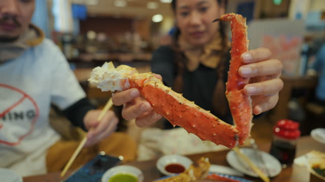 Asian women carry Taraba king crab for photo capture