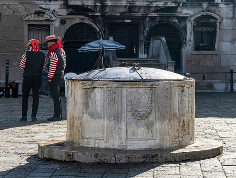 Old water well with gondolier in Venice, Italy