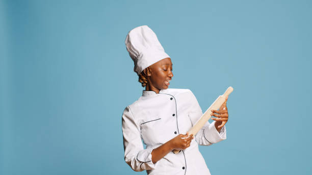 istock Smiling positive cook playing with rolling pin and singing 1466929287