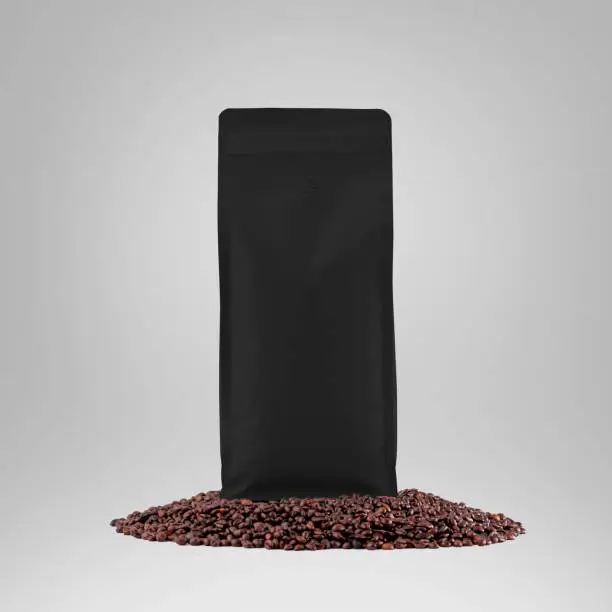 Black gusset packaging mockup with degassing valve, presentation of stable pouch on coffee beans, isolated on background. Premium container template for design, advertising in coffee shops.