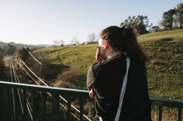 Woman leaning on a bridge fence