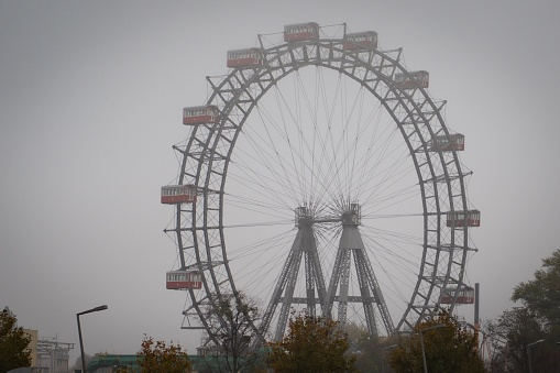 A Ferris wheel under a foggy sky