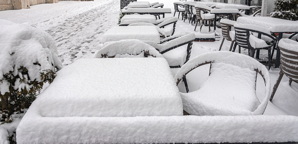 The terrace of the cafe is covered with the first snow of the year