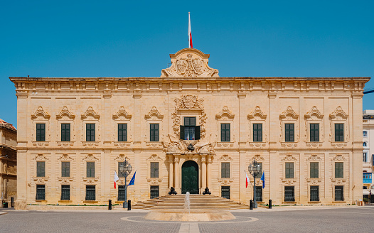 Valletta, Malta - June 1st 2020: The Maltese flag flying over the Auberge de Castille built in the 1740s which has been used as the Office of the Prime Minister of Malta since 1972.