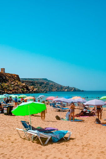 Mellieha, Malta - September 5, 2022: Some people enjoy in the famous Golden Bay beach, in Mellieha, Malta, on a summer day
