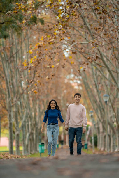 istock Young couple walking hand in hand in the park 1466946448