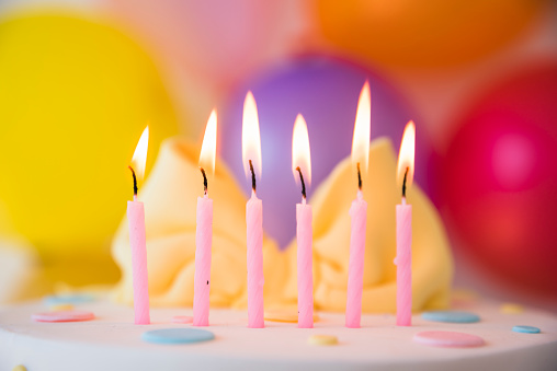 A closeup of birthday cake with candles with blurrd background