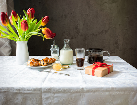 Breakfast with tulips and coffee on the table