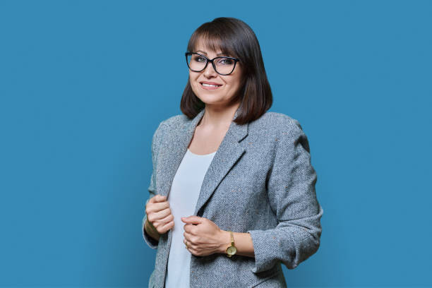 istock Business middle aged woman looking at camera on blue background 1466947649