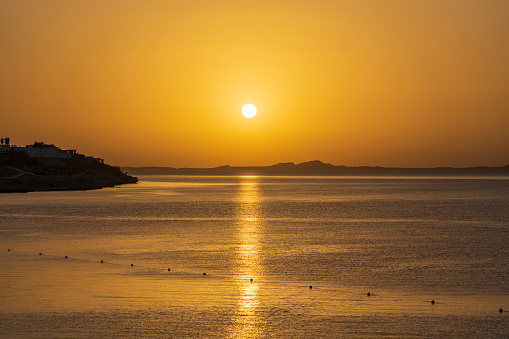 Beautiful sunrise over sea water in Sharm El Sheikh, Egypt. Travel and nature concept. Morning sky, sun and sea water