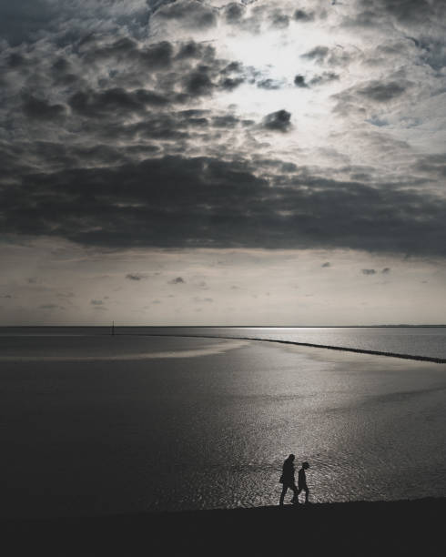 istock Grayscale of two people walking along the lake 1466950957