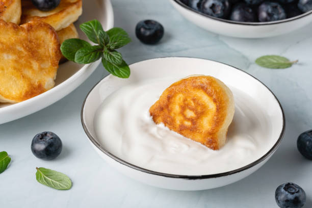 Homemade mini pancakes with sour cream and blueberries