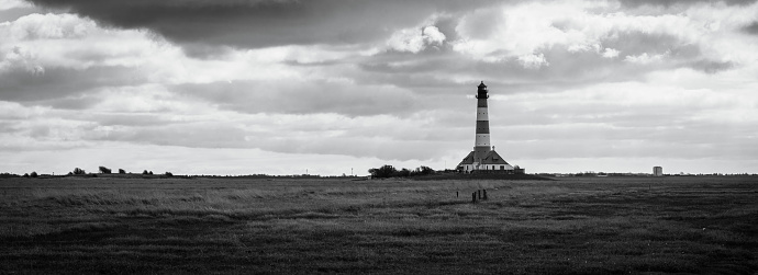 A panoramic view of a lighthouse in a field