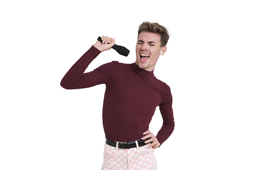 Young caucasian man singing with a microphone. Isolated over white background.