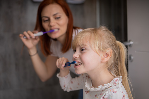 Mid adult mother is teaching her daughter healthy habits