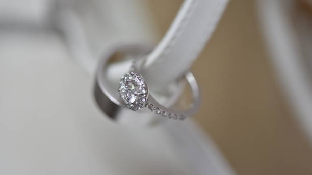istock Selective focus of two beautiful silver diamond engagement rings on a white ribbon 1466960365
