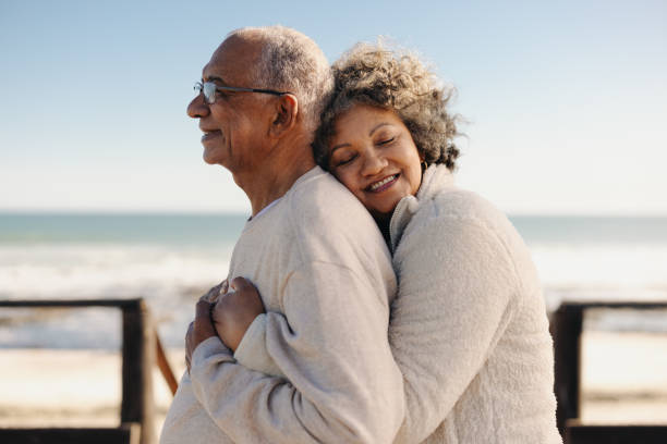 istock Affectionate senior woman embracing her husband at the beach 1466960556