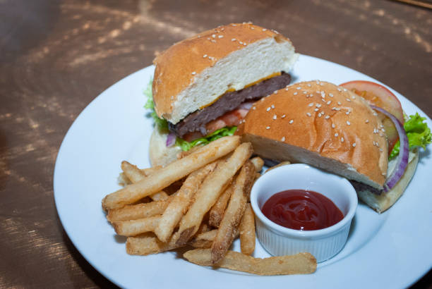 istock Tasty hamburger with lettuce and tomato cheese, served on white plate on table 1466962458