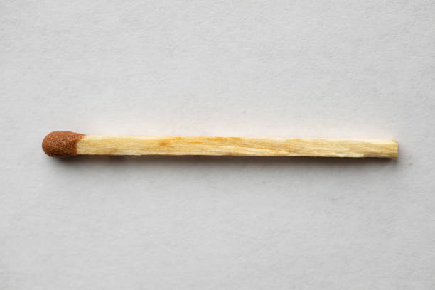 Closeup of a match on a white surface A closeup of a match on a white surface unlit match stock pictures, royalty-free photos & images