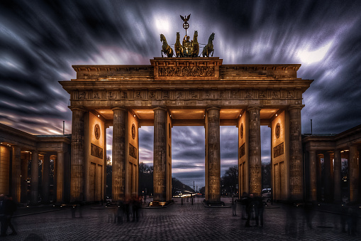 The view of Brandenburg Gate against the dark cloudy sky. Berlin, Germany.