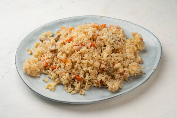 istock Pilaf with meat and vegetables on a large plate, light background. 1466965303